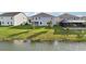 A backyard on a waterfront property features green grass, trees, and a patio at 4949 Olivia Ct, St Cloud, FL 34772