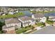Aerial view featuring home with landscaping, gray exterior, red door, brick driveway in a community along a lake at 4949 Olivia Ct, St Cloud, FL 34772