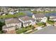 Aerial view featuring home with landscaping, gray exterior, red door, brick driveway in a community along a lake at 4949 Olivia Ct, St Cloud, FL 34772