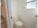Cozy half bath with tile flooring, window, toilet, and vanity with granite countertop at 4712 Hemingway House St, Kissimmee, FL 34746