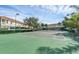 Community tennis court with green surface and surrounded by lush green trees at 4712 Hemingway House St, Kissimmee, FL 34746