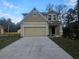 Two-story house with beige siding, a two-car garage, and a manicured lawn at 2933 Mango Tree Dr, Edgewater, FL 32141