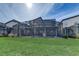 A backyard view showcasing a screened-in pool area with a well-maintained lawn and modern house exterior at 2933 Fable St, Kissimmee, FL 34746