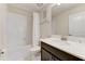 Well-lit bathroom featuring a shower-tub combo, dark wood cabinets, and a clean white countertop sink at 2933 Fable St, Kissimmee, FL 34746