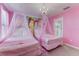 Adorable pink themed bedroom featuring twin beds under princess themed canopies at 2933 Fable St, Kissimmee, FL 34746