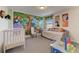 Charming Bedroom with a safari themed mural, baby furniture, and colorful decor on the wall at 2933 Fable St, Kissimmee, FL 34746
