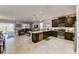 Open-concept kitchen with dark cabinets, a center island, and a seamless flow to the living area at 2933 Fable St, Kissimmee, FL 34746