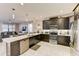 Modern kitchen with dark cabinetry, a center island, and stainless steel appliances flowing into the living area at 2933 Fable St, Kissimmee, FL 34746