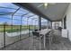Covered patio with outdoor dining set overlooking the pool and beautiful water view at 2933 Fable St, Kissimmee, FL 34746