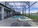 Screened pool area with a spa, lounge chairs, and a beautiful view of the lake at 2933 Fable St, Kissimmee, FL 34746