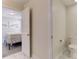 Hallway view of a half-bathroom with white marble tile leading to bedroom with gray carpet at 2933 Fable St, Kissimmee, FL 34746