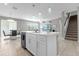 Open-concept kitchen island featuring white countertops and cabinets, seamlessly connecting to the living and dining areas at 3318 Current Ave, Winter Garden, FL 34787