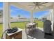 Covered patio with an outdoor table, chairs, ceiling fan and a green lawn at 3318 Current Ave, Winter Garden, FL 34787