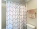 Bathroom featuring a tub with geometric patterned shower curtain, towel rack, and toilet at 750 E Michigan St # 163, Orlando, FL 32806