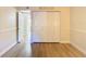 A bright bedroom features hardwood floors, a double closet, and light colored walls at 750 E Michigan St # 163, Orlando, FL 32806