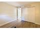 A bright bedroom features hardwood floors, a double closet, and light colored walls at 750 E Michigan St # 163, Orlando, FL 32806