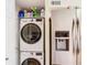 Convenient laundry area with stacked washer and dryer next to a modern refrigerator at 750 E Michigan St # 163, Orlando, FL 32806