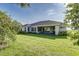 The backyard features lush green grass, landscaping, and mature trees at 839 Waterfern Trail Dr, Auburndale, FL 33823