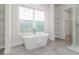 Elegant bathroom boasts a freestanding tub, large window, and tiled shower at 839 Waterfern Trail Dr, Auburndale, FL 33823