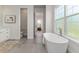 Bright bathroom with a soaking tub, walk-in shower, and access to bedroom at 839 Waterfern Trail Dr, Auburndale, FL 33823