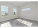 Sun-filled bedroom showcases three windows, tile floors and neutral paint at 839 Waterfern Trail Dr, Auburndale, FL 33823