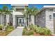 Close-up of the home's entry, featuring double doors and tropical plants at 839 Waterfern Trail Dr, Auburndale, FL 33823