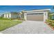 Beautifully landscaped home featuring a paver driveway leading to a two-car garage at 839 Waterfern Trail Dr, Auburndale, FL 33823