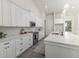 Modern kitchen featuring white cabinets, sleek countertops, stainless steel appliances, and ample storage at 839 Waterfern Trail Dr, Auburndale, FL 33823