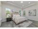Bright main bedroom with a king bed, tray ceiling, and dual windows at 839 Waterfern Trail Dr, Auburndale, FL 33823