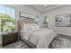 Bright main bedroom with a king bed, tray ceiling, and dual windows at 839 Waterfern Trail Dr, Auburndale, FL 33823