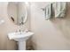 Small powder room with pedestal sink and oval mirror at 1429 Milledge Ln # 1429, Davenport, FL 33896