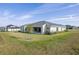 Home's backyard with covered patio, landscaping, and grassy area at 208 Snowy Orchid Way, Lake Alfred, FL 33850