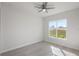 Bright bedroom with large window, ceiling fan, and light grey wood-look flooring at 208 Snowy Orchid Way, Lake Alfred, FL 33850