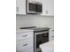 Modern kitchen with stainless steel appliances and white cabinetry at 208 Snowy Orchid Way, Lake Alfred, FL 33850