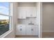 Well-lit laundry room with white cabinets and countertop at 208 Snowy Orchid Way, Lake Alfred, FL 33850