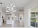 Open concept living area with light flooring and modern chandelier at 208 Snowy Orchid Way, Lake Alfred, FL 33850