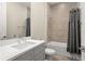 Clean bathroom featuring a modern vanity, tiled walls, a bathtub with a shower, and a sleek toilet at 15820 Vetta Dr, Montverde, FL 34756