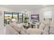 Bright living room featuring a modern sofa, large windows, and an entertainment center with a TV at 15820 Vetta Dr, Montverde, FL 34756