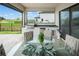 Covered patio featuring a built-in outdoor kitchen and dining area with views of the pool and green landscape at 15820 Vetta Dr, Montverde, FL 34756