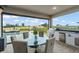 Covered patio with outdoor kitchen, dining area, and a picturesque view of the golf course and swimming pool at 15820 Vetta Dr, Montverde, FL 34756
