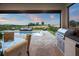 Backyard swimming pool and tanning ledge, with an outdoor seating area, grill, and view of the golf course at 15820 Vetta Dr, Montverde, FL 34756