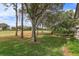 Landscaped backyard with mature trees and golf course views at 6130 Blakeford Dr, Windermere, FL 34786