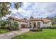 Stunning two-story home with a tile roof, palm trees, and a brick paved driveway at 6130 Blakeford Dr, Windermere, FL 34786
