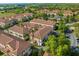 Wide aerial view of a residential area filled with multi-story townhomes, lush landscaping, and ample parking at 637 Pavia Loop, Lake Mary, FL 32746