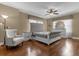 Spacious bedroom with hardwood floors, a large bed, and an armchair at 637 Pavia Loop, Lake Mary, FL 32746