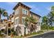 Tan three-story townhome with a Spanish-style roof and lush landscaping at 637 Pavia Loop, Lake Mary, FL 32746