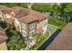 Stunning multi-story townhome featuring a clay tile roof, manicured landscaping, and attached garages at 637 Pavia Loop, Lake Mary, FL 32746