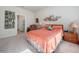 Bright bedroom featuring neutral carpet, ensuite bathroom access, and unique wall art at 2542 Cliff Way, St Cloud, FL 34771