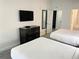 This spacious bedroom features two beds, a mounted TV, and modern decor at 14501 Grove Resort Ave # 3109, Winter Garden, FL 34787
