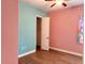 Bedroom with pink and teal walls, wood flooring, and closet at 32702 View Haven Ln, Sorrento, FL 32776